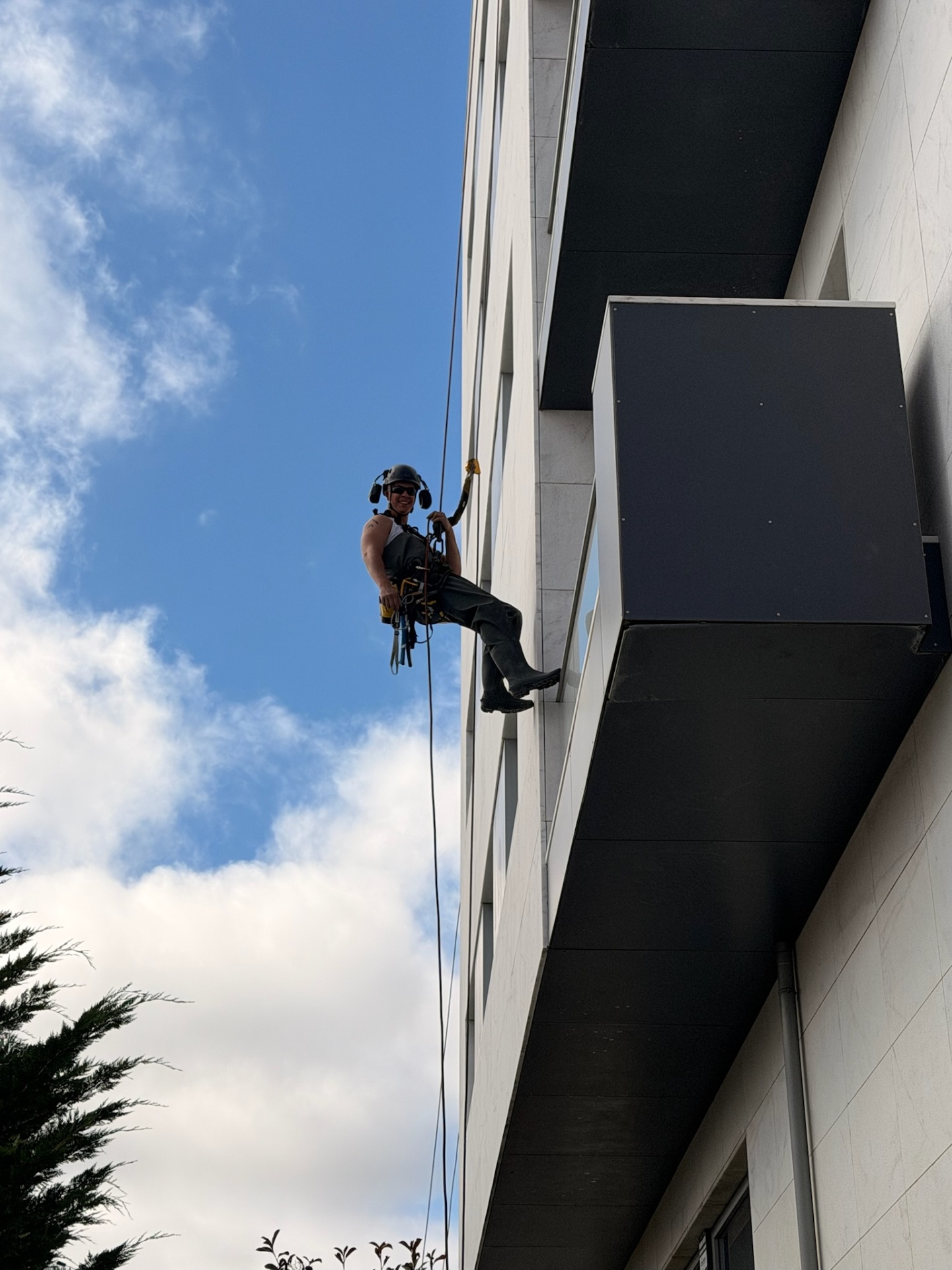 Técnico da RopeX em acesso por cordas numa fachada de edifício