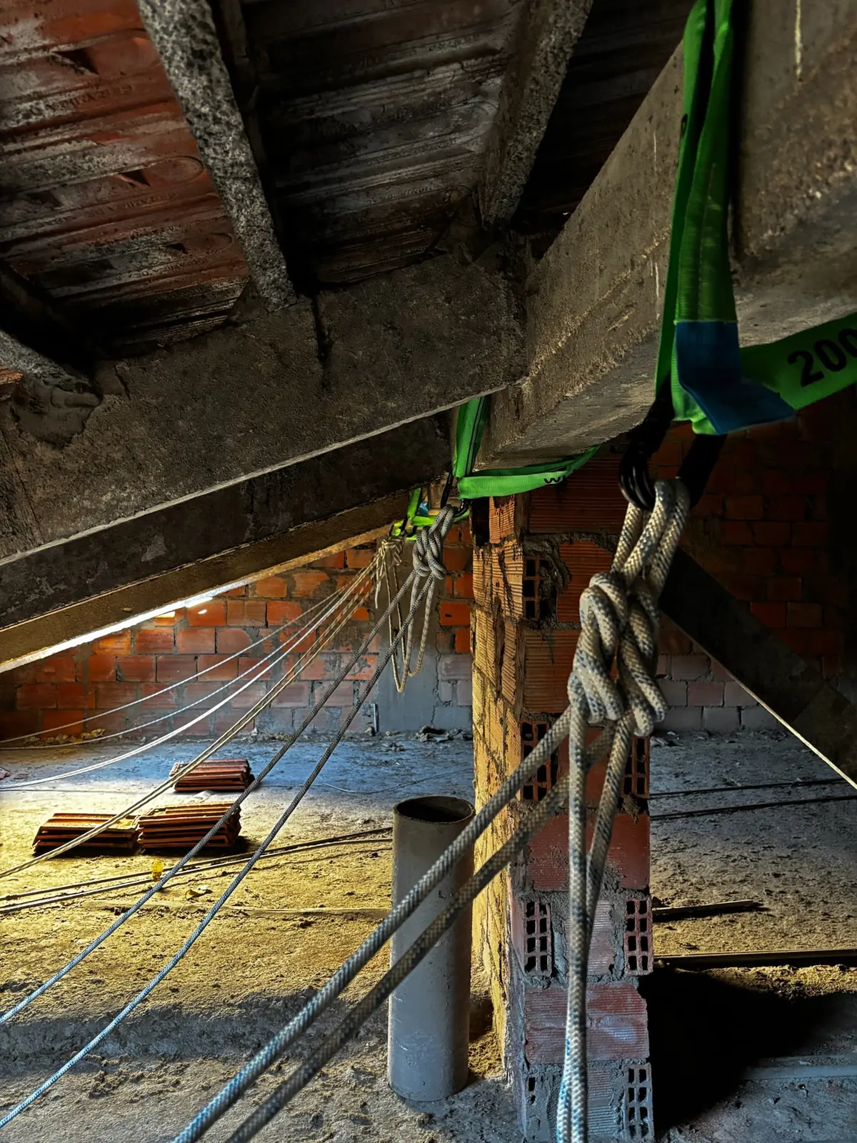 Ancoragem das cordas com fitas e nós numa viga de betão, antes de um trabalho em altura