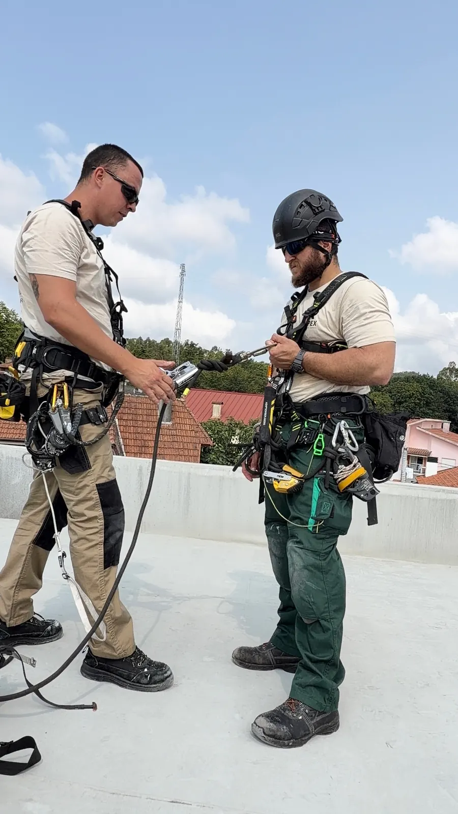 Dois técnicos da RopeX na cobertura a preparar o equipamento de cordas antes da descida