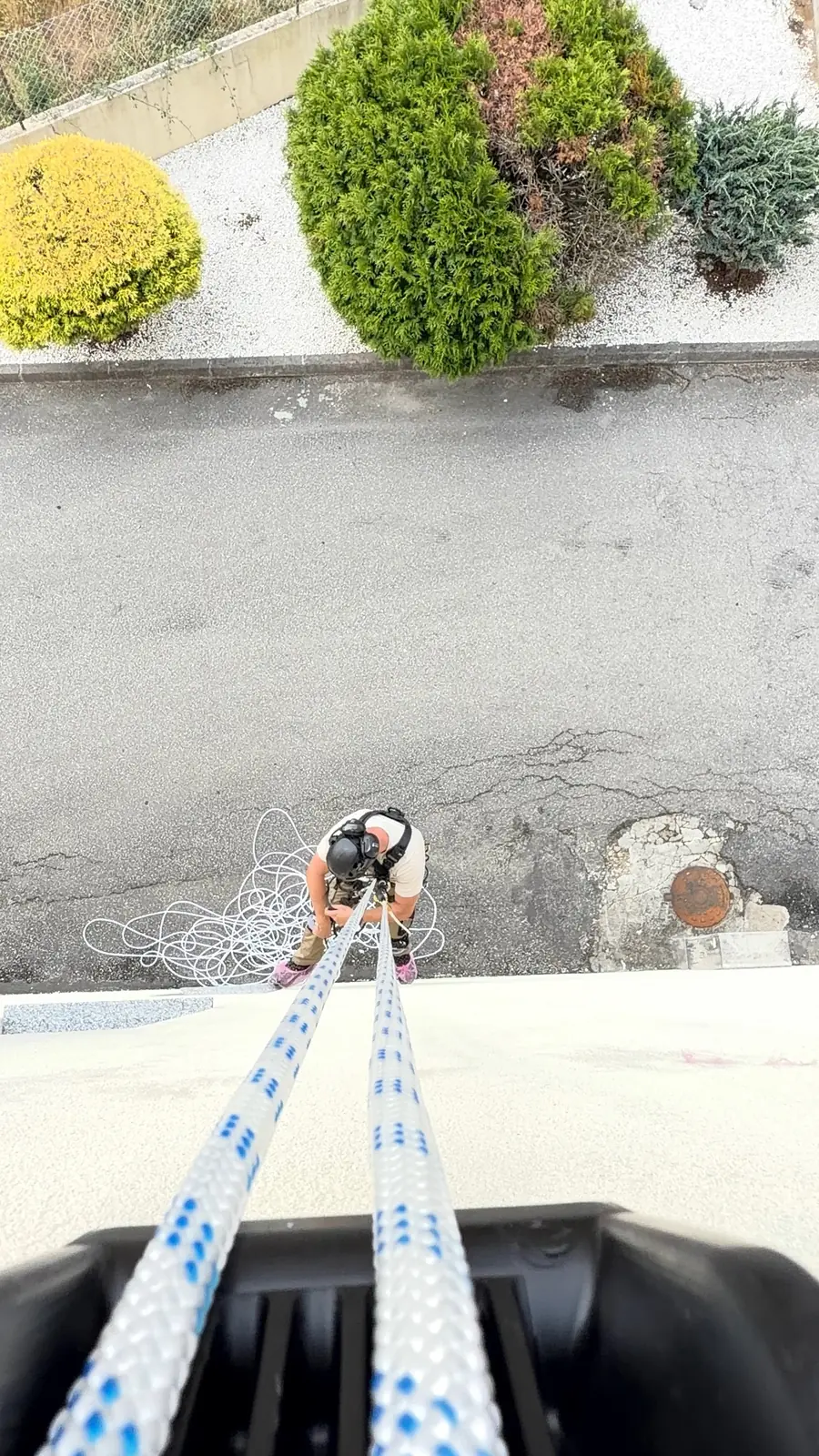 Duas cordas descem do topo do edifício até ao técnico da RopeX, lá em baixo na rua