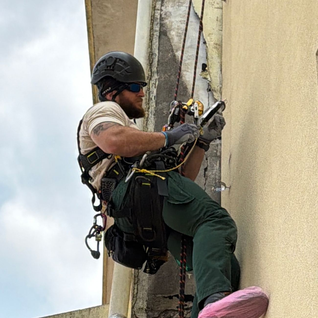 Técnico apoiado na parede durante a descida controlada