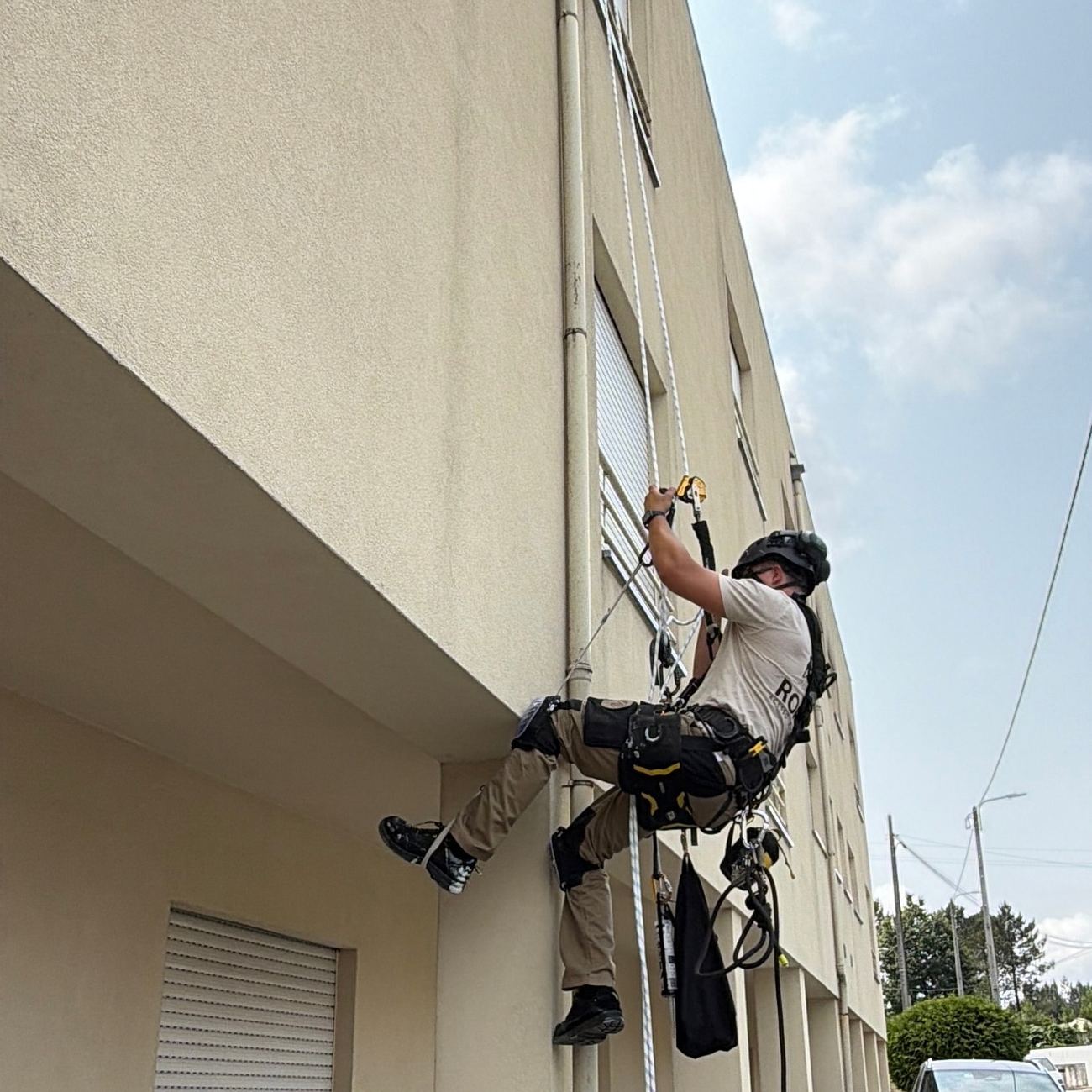 Edifício em intervenção, com o técnico a meio da fachada