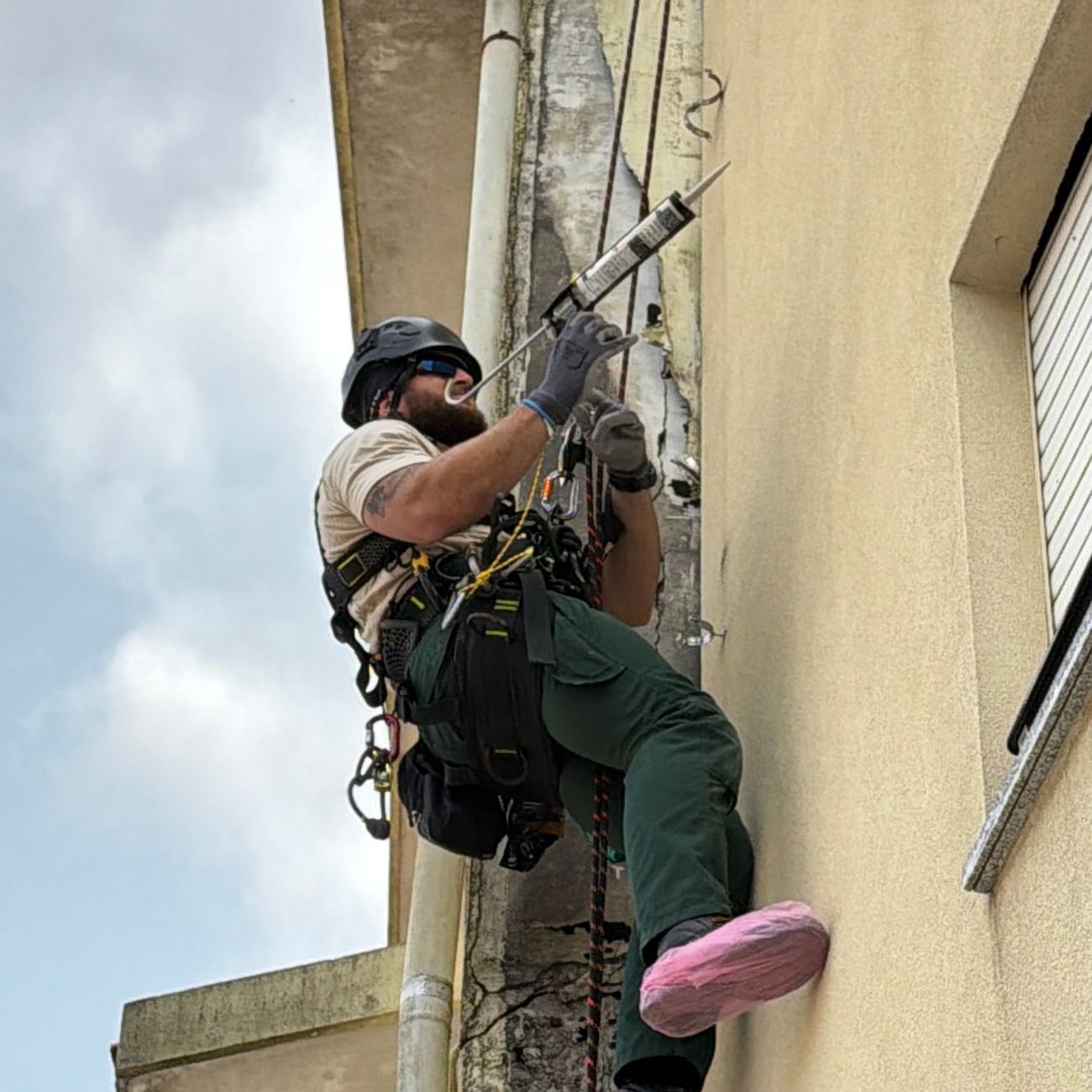 Trabalho numa junta vertical da fachada por acesso por cordas