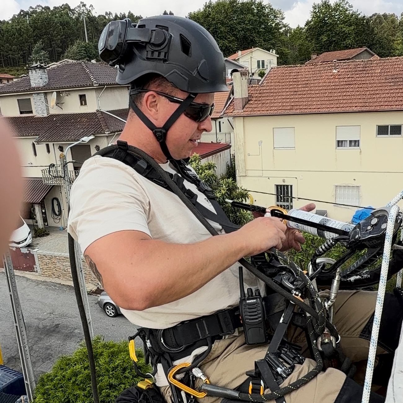 Técnico da RopeX a preparar a corda antes da descida, com a rua ao fundo
